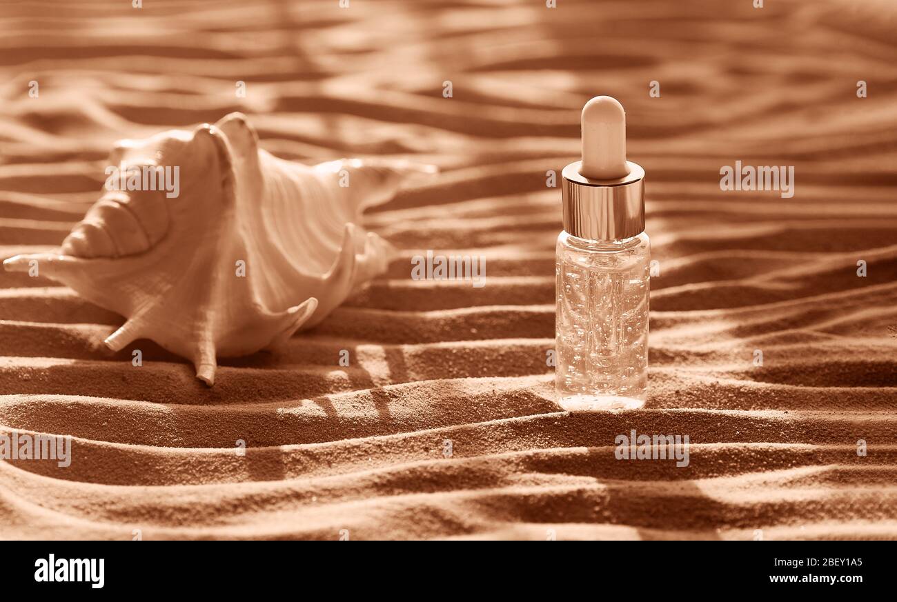 Feuchtigkeitsspendende Gesichtsserum in einer transparenten Flasche enthält Partikel von Gold. Beauty- und Wellness-Konzept. Toning Pfirsich-Gelato. Nahaufnahme. Stockfoto