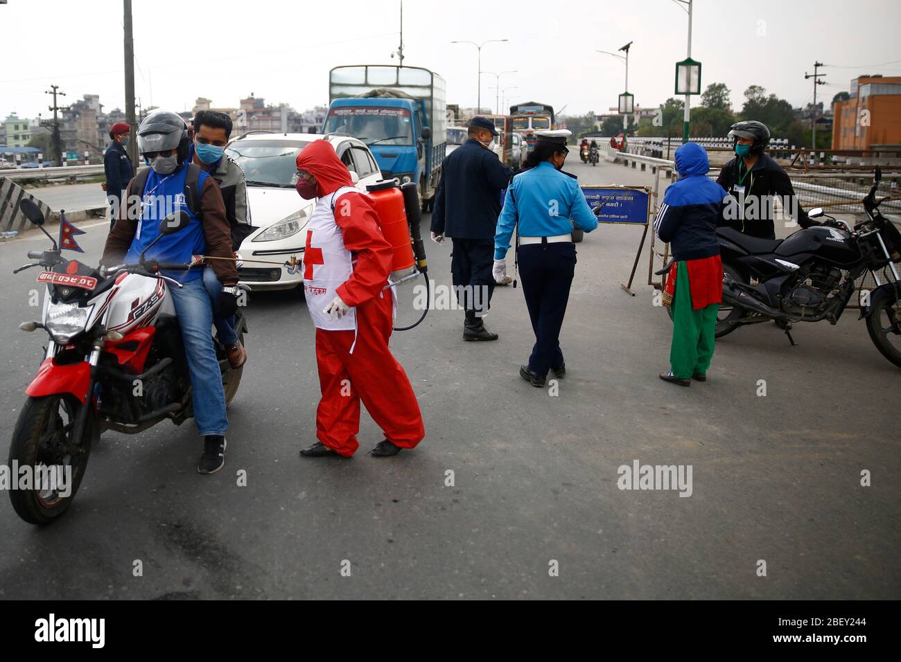 Kathmandu, Nepal. April 2020. Eine Frau vom Roten Kreuz desinfiziert Fahrzeuge an einem Polizeikontrollpunkt entlang der Grenze von Kathmandu und Bhaktapur am 24. Tag einer Regierung, die am Donnerstag, dem 16. April 2020, wegen der Ausbreitung der Coronavirus-Ansteckung in Nepal eine Sperre verhängt hat. Kredit: Skanda Gautam/ZUMA Wire/Alamy Live News Stockfoto