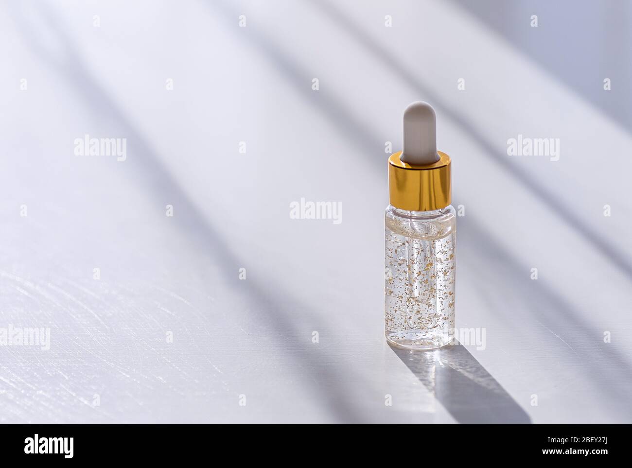 Feuchtigkeitsspendende Gesichtsbehandlung in einer transparenten Flasche auf weißem Hintergrund. Asiatische Kosmetik, Gel mit Schneckenextrakt. Layout-Stil. Schönheit und Gesundheit concep Stockfoto