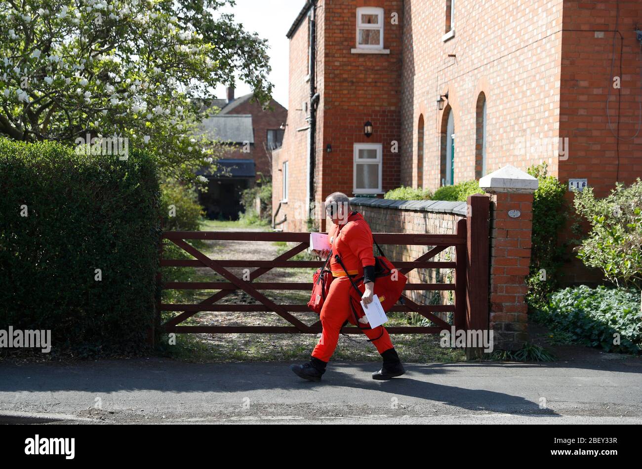 Loughborough, Leicestershire, Großbritannien. April 2020. Royal Mail Postmann Kevin Allen trägt Mr Incredible Fancy Dress zur Unterstützung des NHS, während er Post während der Coronavirus Pandemie Sperrung liefert. Credit Darren Staples/Alamy Live News. Stockfoto