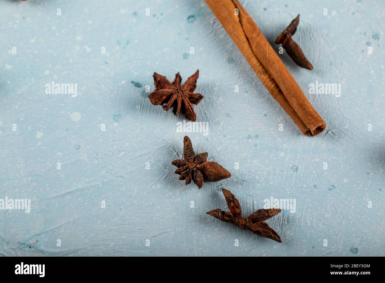 Zimtstangen mit Anisblüten auf einem blauen Tisch Stockfoto