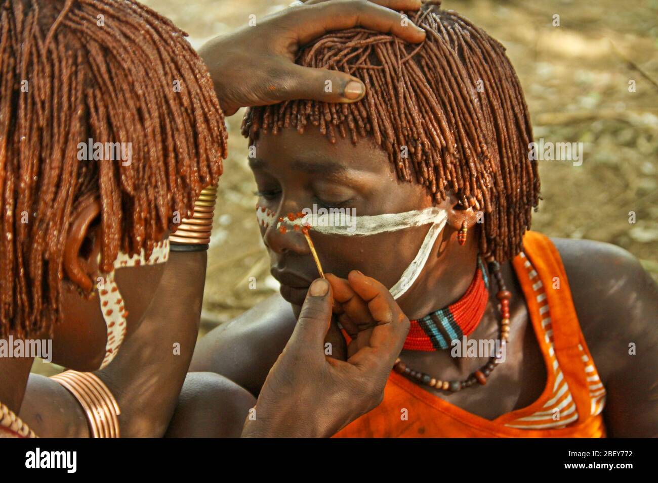 Vor Beginn einer Stammeszeremonie tragen Hamer Tribesmen Gesichtsfarbe auf. Fotografiert im Omo River Valley, Äthiopien Stockfoto
