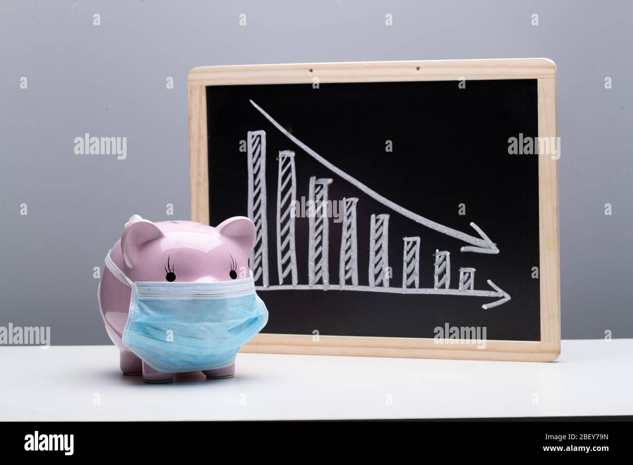 Tragen einer Maske von Ferkel und Rückgang Trend Chart Stockfoto