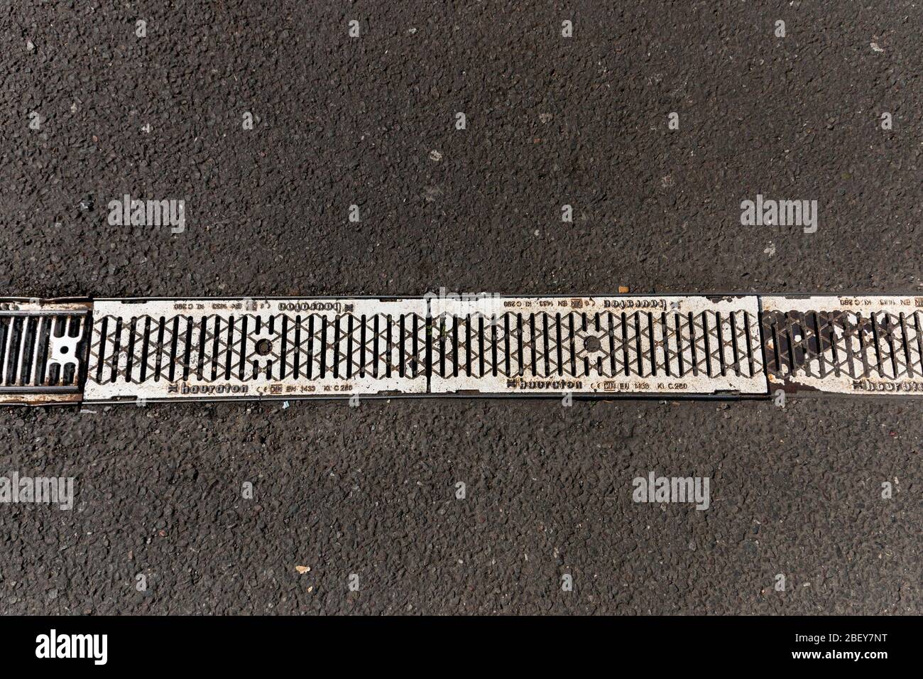 Eine Nahaufnahme einer kleinen Entwässerungsrinne auf einem geteerten Parkplatz Stockfoto