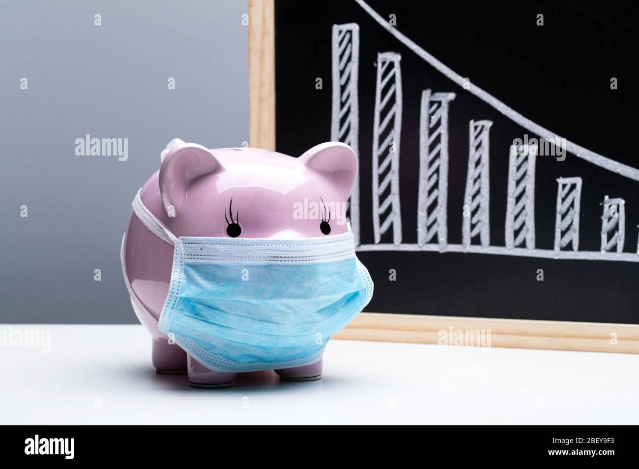 Tragen einer Maske von Ferkel und Rückgang Trend Chart Stockfoto