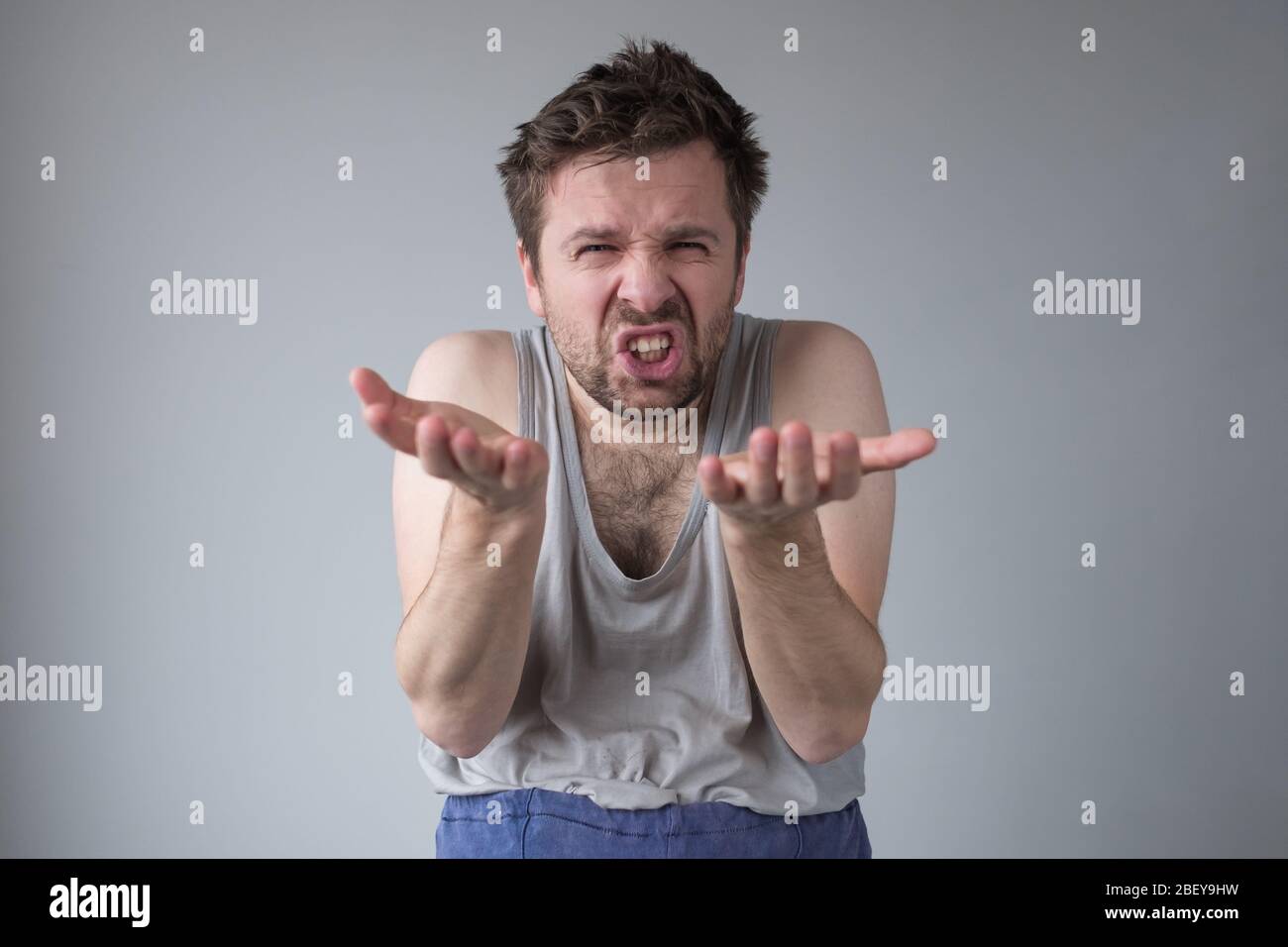 Wütend irritierten Mann mit erhobenen Fäusten und geballten Zähnen stehen, erleben starke Aggression, Wut Management-Probleme. Innenaufnahmen im Studio Stockfoto