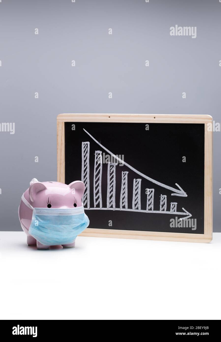 Tragen einer Maske von Ferkel und Rückgang Trend Chart Stockfoto