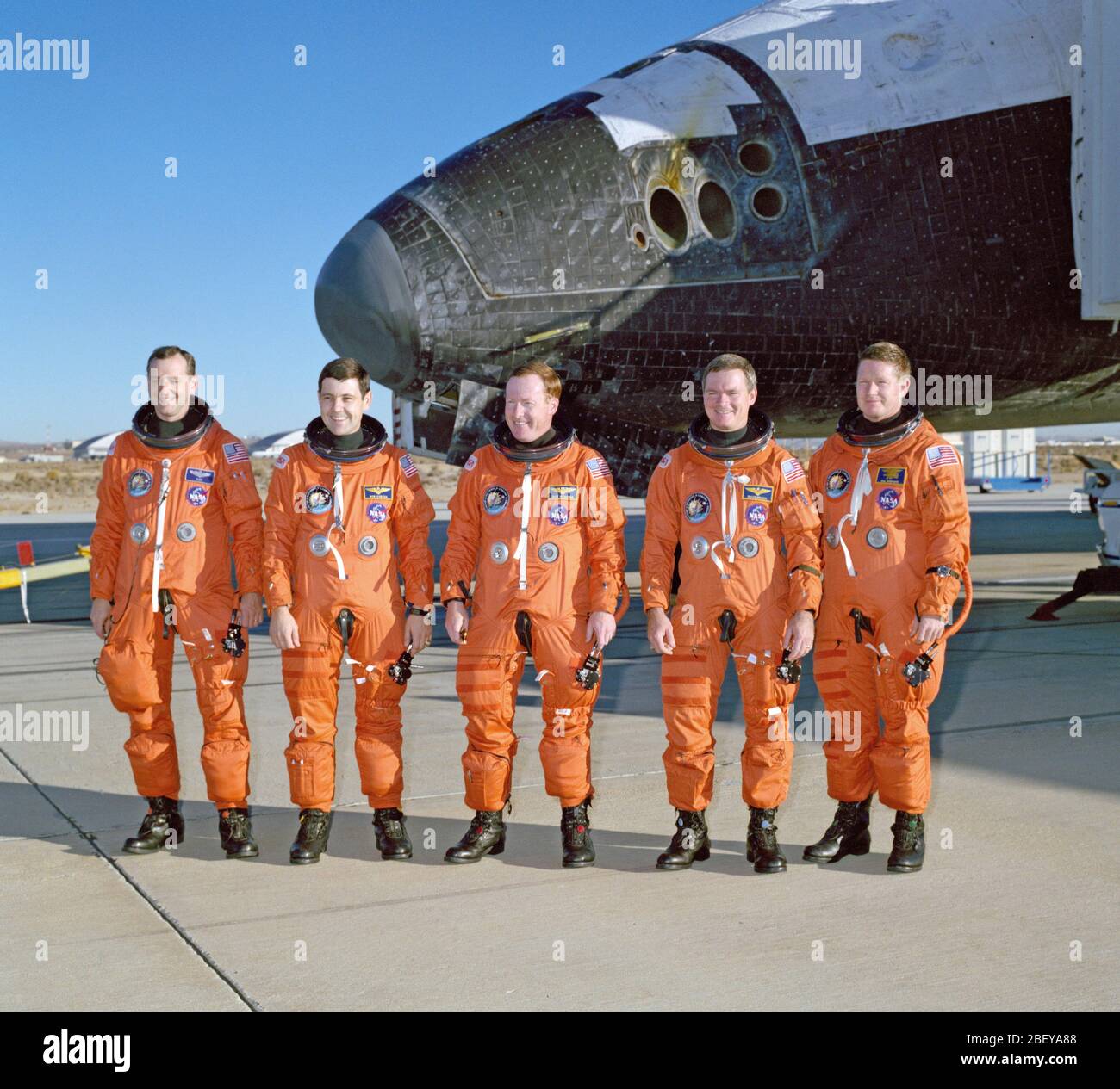 (10 Okt 1990) - - - Die fünf Astronauten Crewmitglieder der letzte Flug der "Discovery" Pose für Ihre erste Foto wieder auf terra firma nach ihrer erfolgreichen vier Tage im Erdorbit. Discovery, teilweise sichtbar in diesem Rahmen, auf der Edwards Air Force Base berührt um 6:57 Uhr PDT, Okt. 10, 1990. Astronauten Richard N. Richards (Mitte) war mission Commander. Er wird hier durch (von links nach rechts) Astronauten Thomas D. Akers, Robert D. Cabana, Bruce E. Melnick und William M. Hirte flankiert. Stockfoto