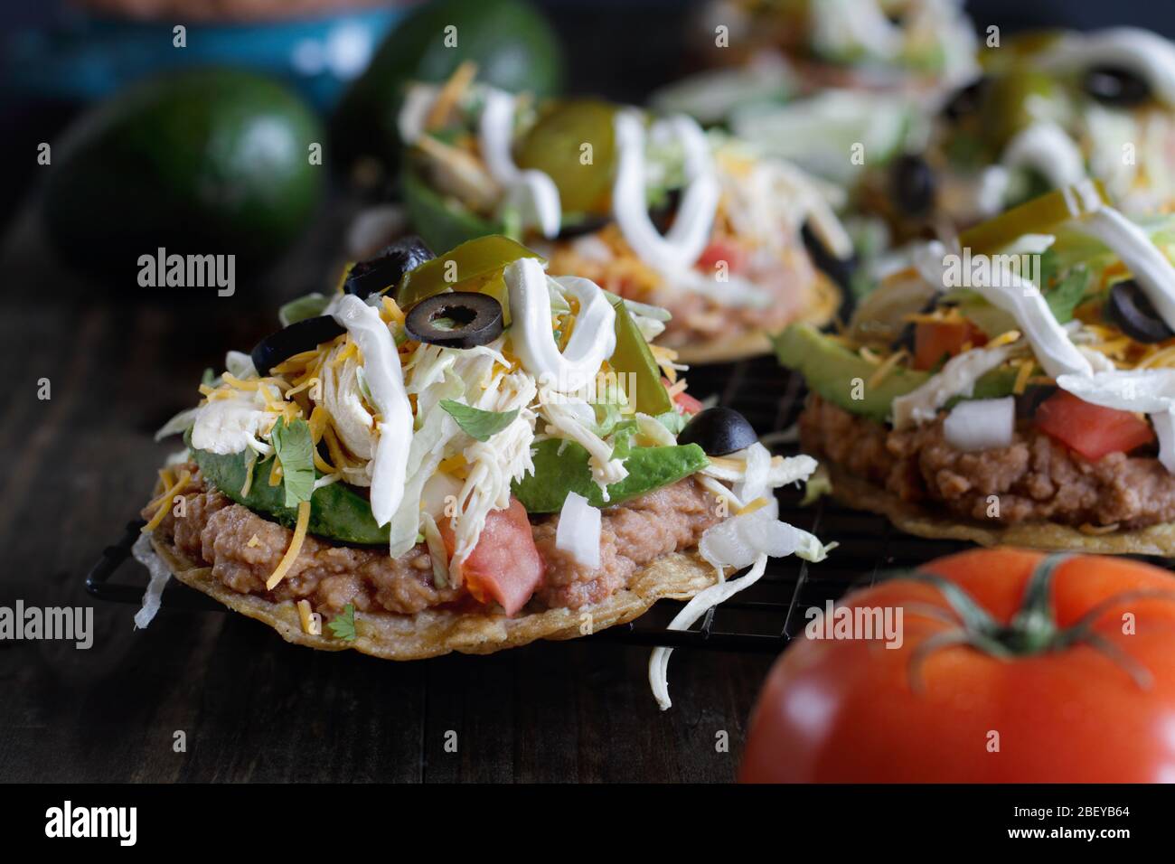 Chicken Tostadas mit Jalapeno Paprika, schwarze Oliven, saure Sahne, Salat, geschreddert Huhn, frischen Koriander, Zwiebeln, gewürfelte Tomaten, gebackene Bohnen, AV Stockfoto