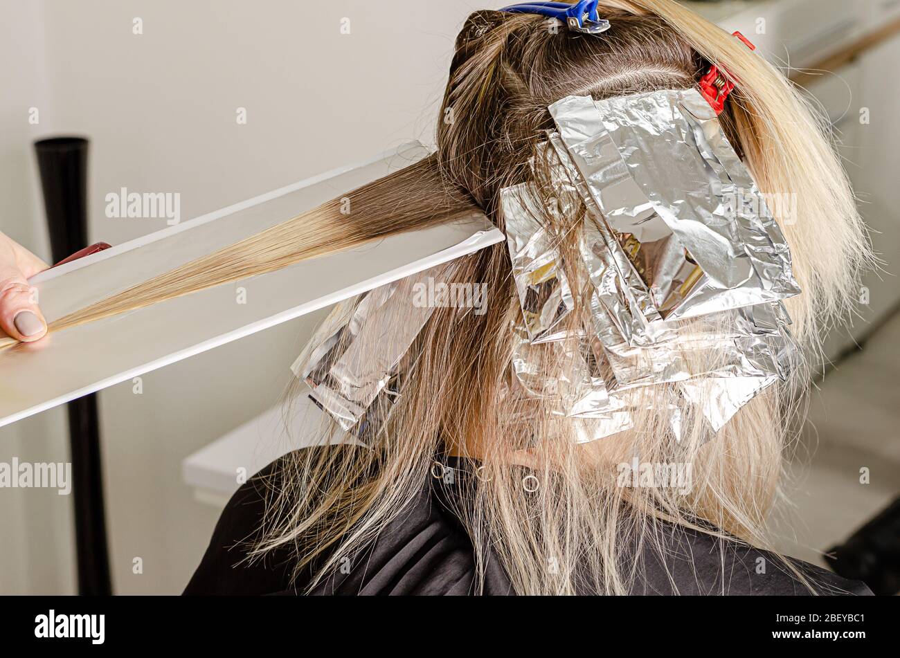 Set Haarfärbeverfahren. Bleichpulver auf das Haar auftragen und in die Folie einwickeln. Air Touch-Technik. Schritt 1 Stockfoto