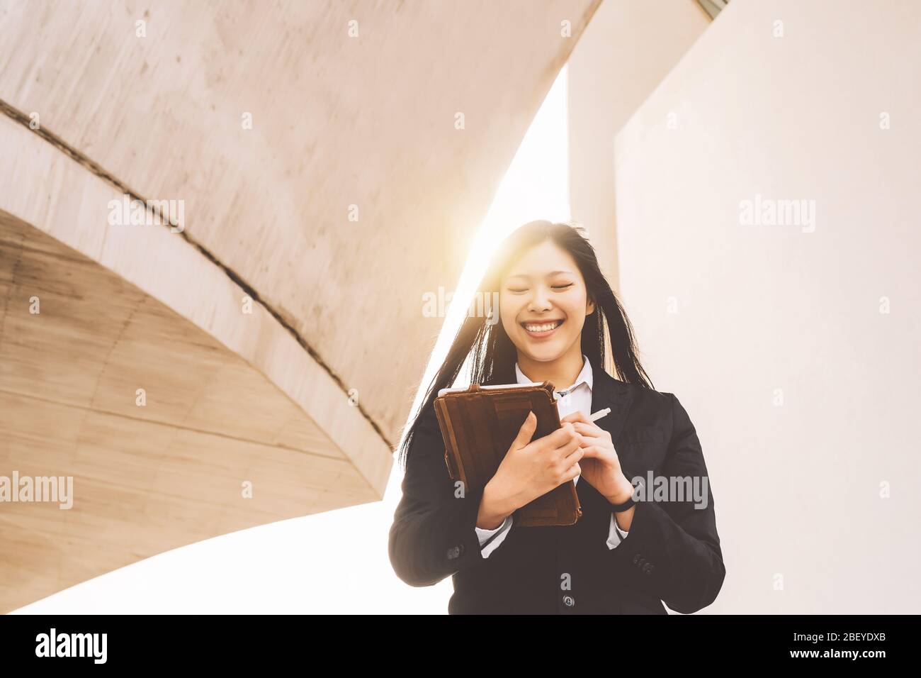 Asiatische Business Woman mit Smart Tablet aus dem Büro - Junge lächelnde chinesische Mädchen bereit für die Arbeit an digitalem Marketing Stockfoto