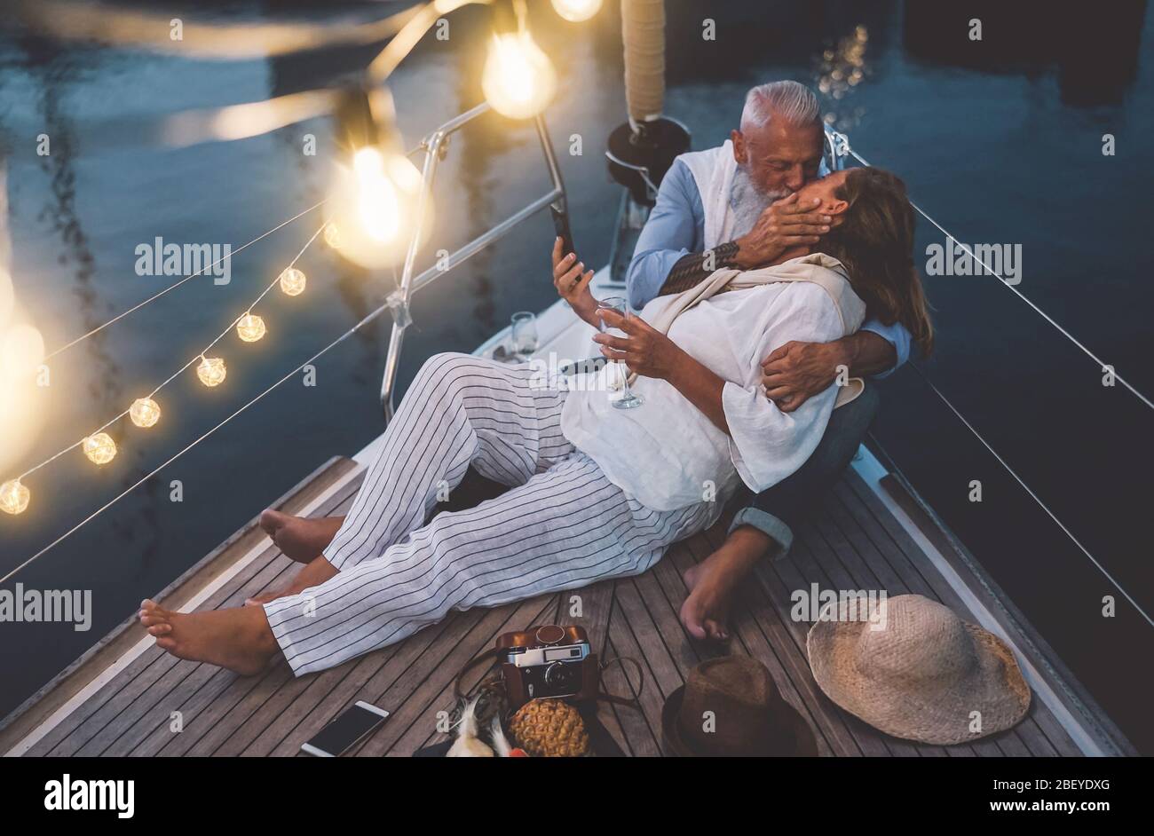 Senior Paar küssen während Segelboot Urlaub - glücklich reifen Menschen mit zarten Momente feiern Hochzeitstag auf Bootsfahrt Stockfoto