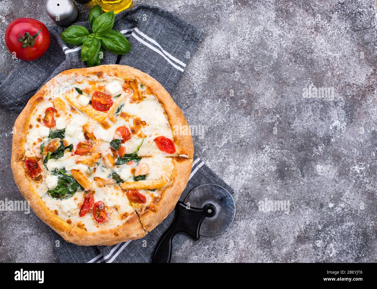 Italienische Pizza mit Tomaten, Mozzarella und Hähnchen Stockfoto