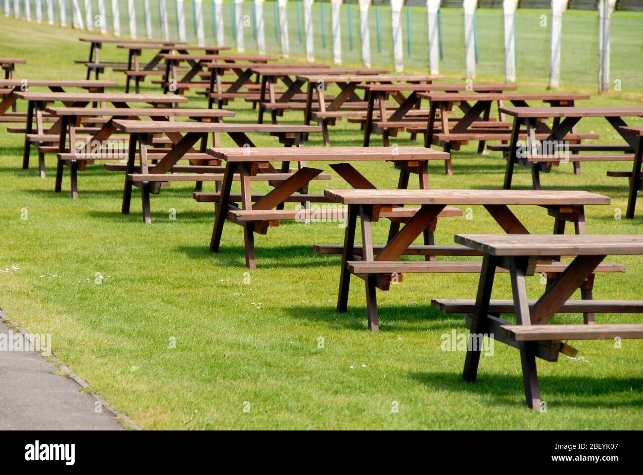 Reihen von leeren Picknicktischen im Sportstadion Stockfoto