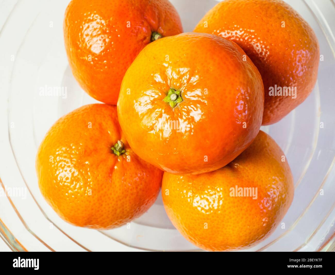 Einfache Schäler Mandarinen in einer Glasschale auf weißem Hintergrund Stockfoto