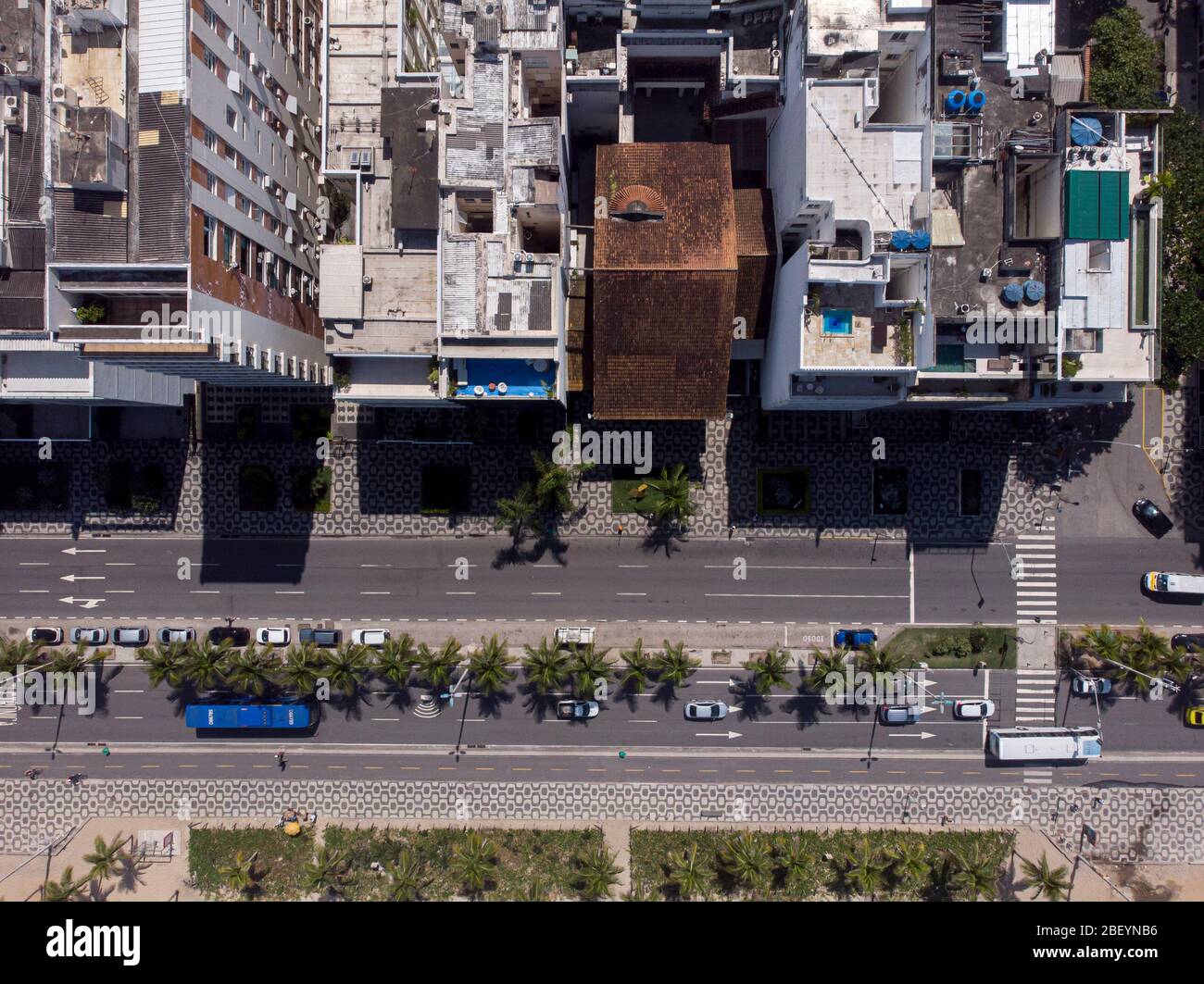 Avenue in Ipanema, Rio de Janeiro, von oben gesehen mit Palmen zwischen den Straßen und entlang des Strandes mit Hochhäusern, die einen Schatten werfen Stockfoto