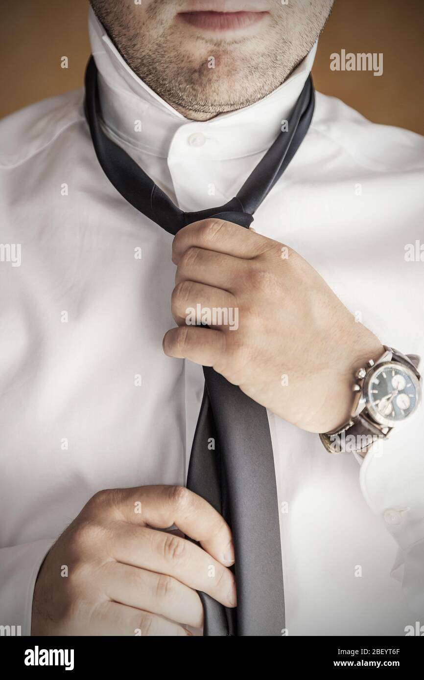 Nahaufnahme des Mannes in weißem Hemd Anziehen und Anpassung Krawatte am Hals - Menschen, Business, Mode und Kleidung Konzept. Stockfoto