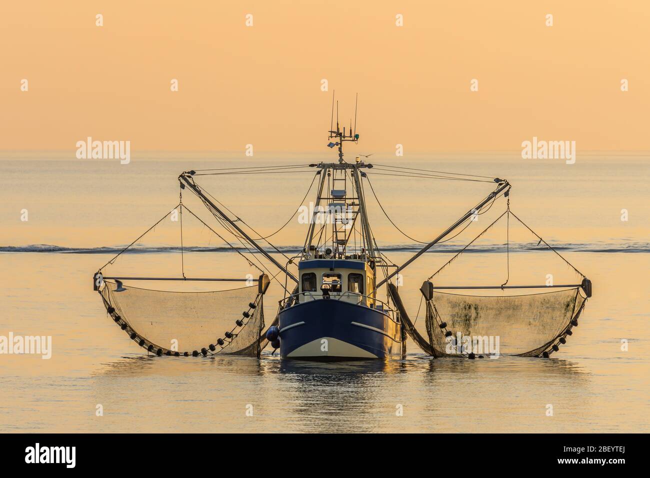 Fischerboot mit Schleppnetzen bei Sonnenuntergang, Büsum, Nordsee, Schleswig-Holstein, Deutschland Stockfoto