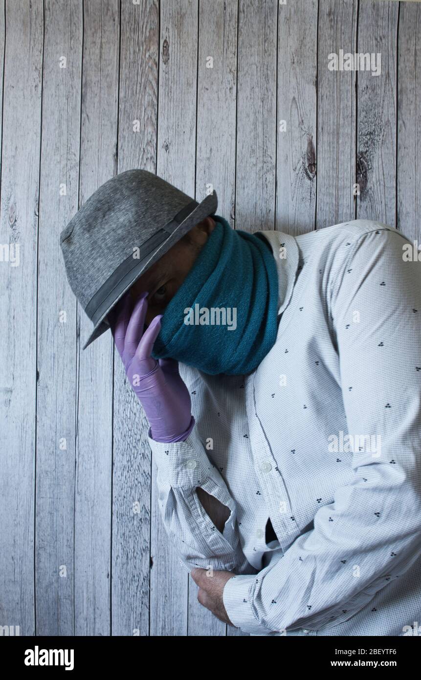 Selbstporträt des Mannes mit Maske/Schal und Hut mit verschiedenen Gesten und Posen Stockfoto
