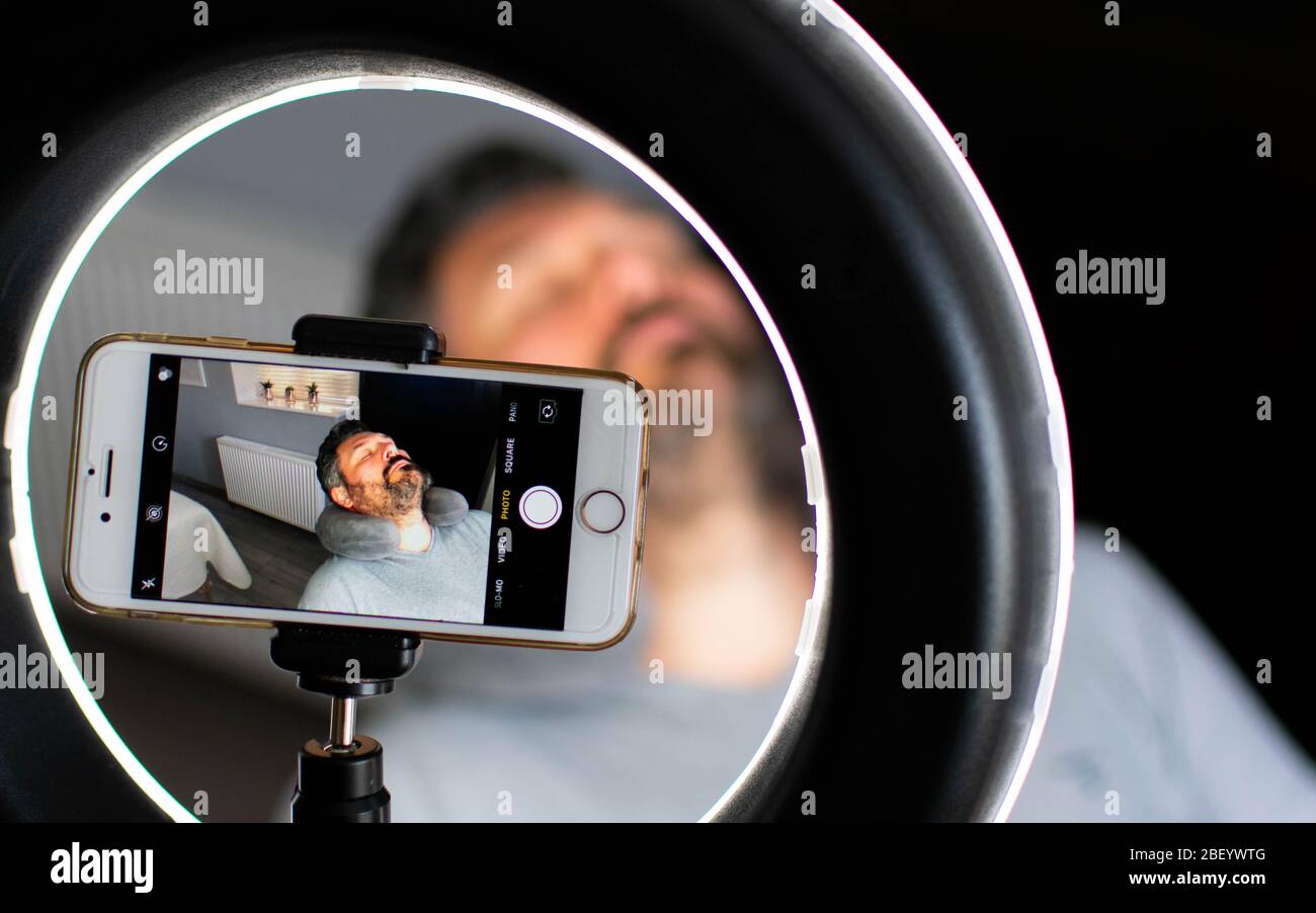 Ein Mann, der auf einem Smartphone fotografiert wird, bevor er eine Schönheitsbehandlung für Männer hat Stockfoto