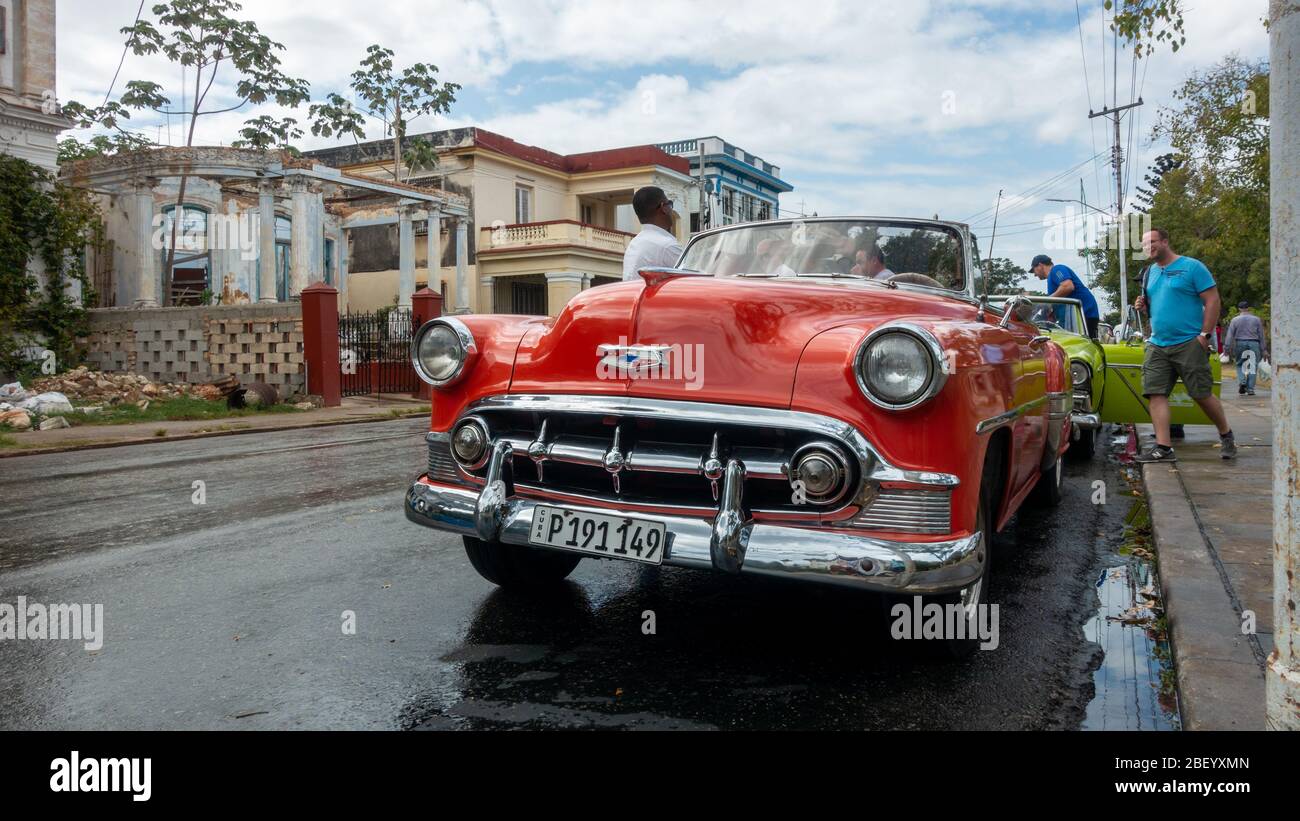 Touristen, die wieder in ihre alten amerikanischen Taxis nach dem Besuch John Lennon Platz in calle 17, Havanna, Kuba Stockfoto