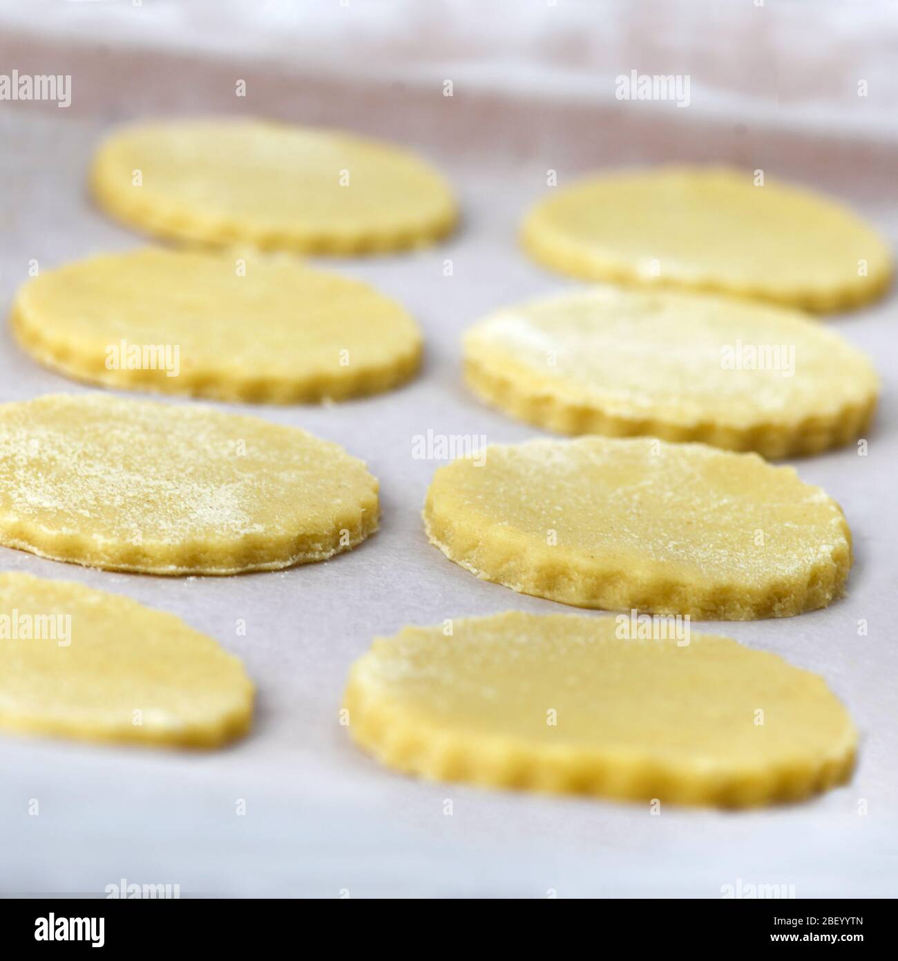 Quadratisches Bild von ungekochten hausgemachten Cookies warten auf den Ofen auf einer Trägerplatte. Aufnahme im Hintergrund mit selektivem Fokus, um Rezept-Overlay hinzuzufügen Stockfoto