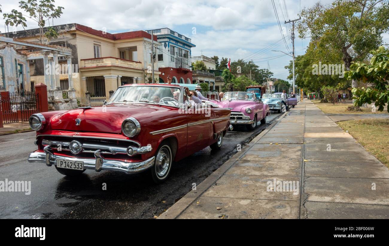 Bunte Linie von Vintage-amerikanischen Taxis mit Touristen nach dem Besuch John Lennon Platz in calle 17, Havanna, Kuba Stockfoto