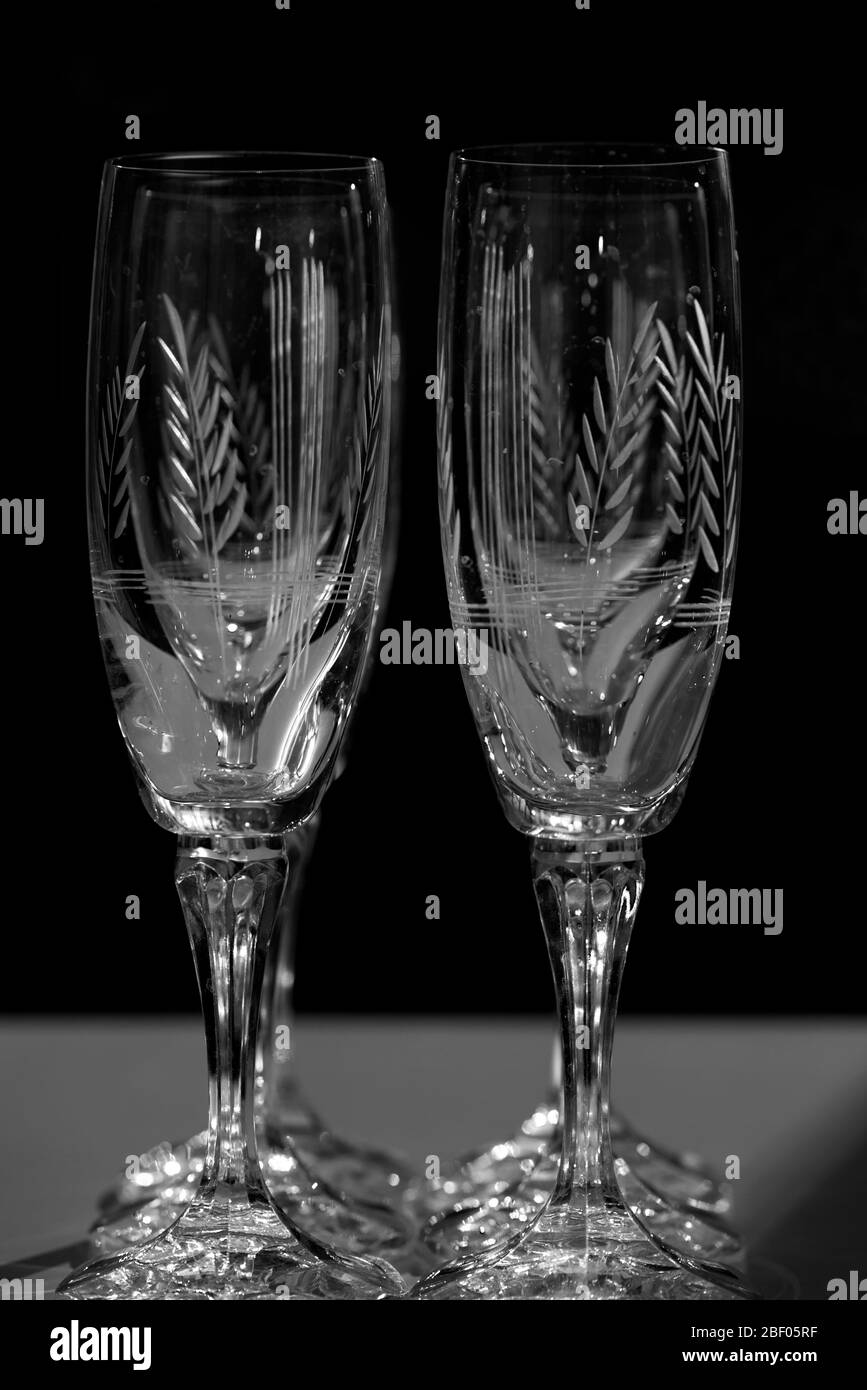 Sektgläser aus Kristall, beleuchtet im dunklen Raum. Stockfoto
