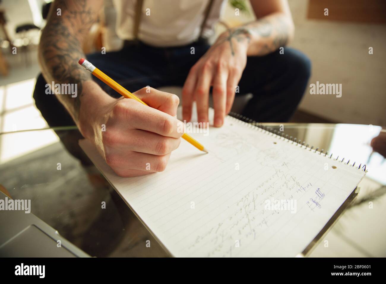 Nahaufnahme von männlichen Händen Schreiben auf einem leeren Papier auf dem Tisch zu Hause. Notizen machen, Arbeitshaus, Bericht für seine Arbeit. Bildung, Freiberufler, Kunst und Business Concept. Hinterlässt Unterschrift, erledigen Papierkram. Stockfoto