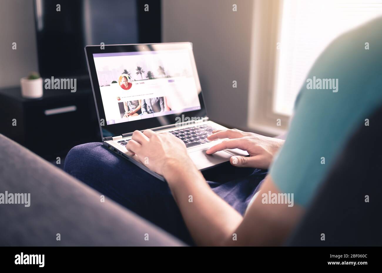 Profil für soziale Medien auf dem Bildschirm. Mann, der zu Hause einen Laptop benutzt. Persönliche Online-Seite. Modell für die Website des Unternehmensnetzwerks. Statusaktualisierung wird geschrieben. Stockfoto