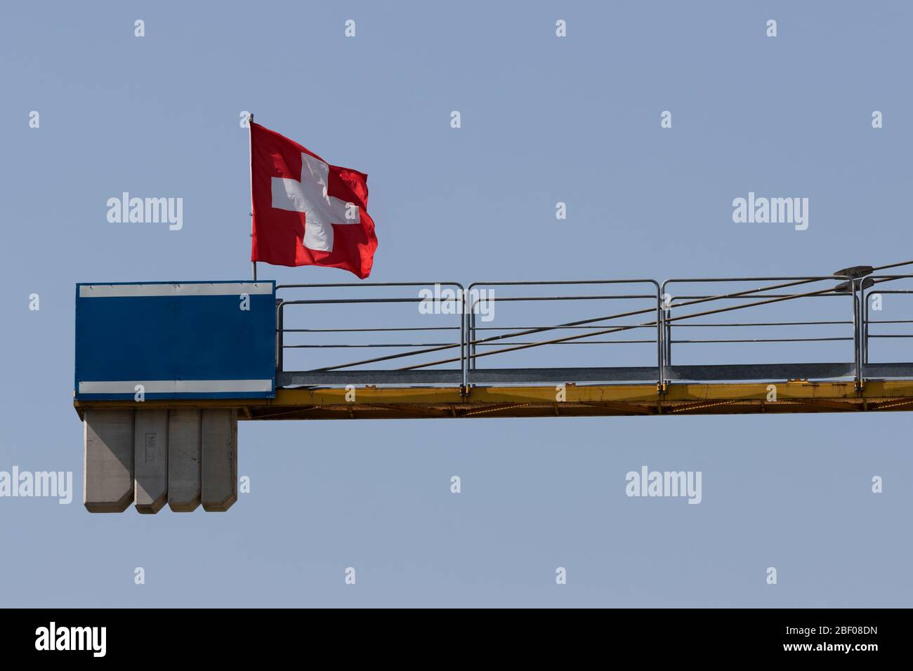 Gelber großer Kran mit Schweizer Flagge, mit Platz für Logo und Texte Stockfoto