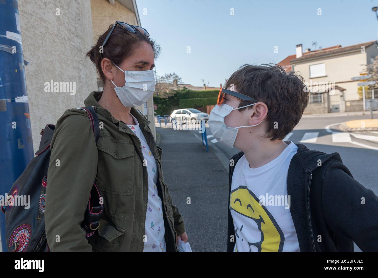 Malissard (Südostfrankreich), 7. April 2020: Eine Frau und ihr kleiner Sohn tragen während der Quarantäne eine Schutzmaske auf einer Straße, Coronavir Stockfoto