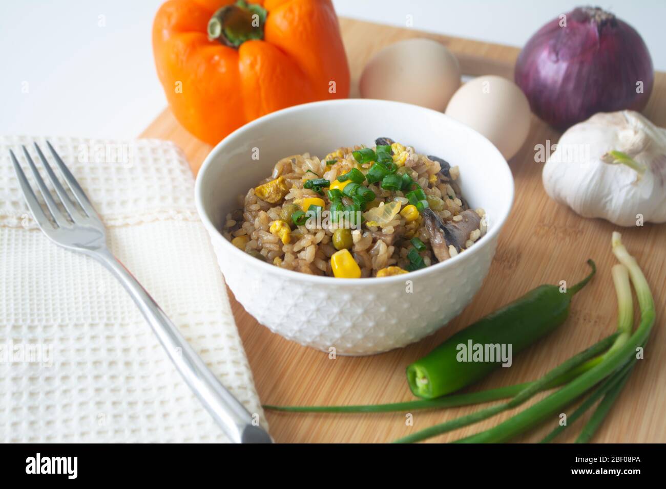 Chinesischer Eiergebratener Reis mit Mais, grünen Erbsen, Zwiebeln, Knoblauch, Pilzen und Frühlingszwiebeln Stockfoto