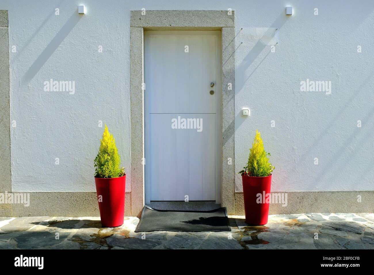 Weiße Tür mit roten Blumentöpfen, camino de santiago, Spanien. Stockfoto