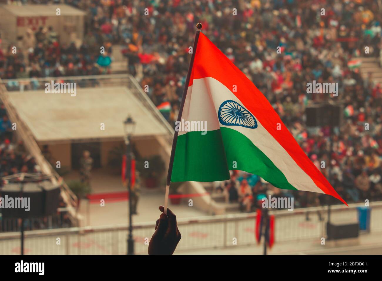 Eine Person, die die indische Flagge an der Wagha-Grenze in Amritsar, Punjab, hochhebt. Stockfoto