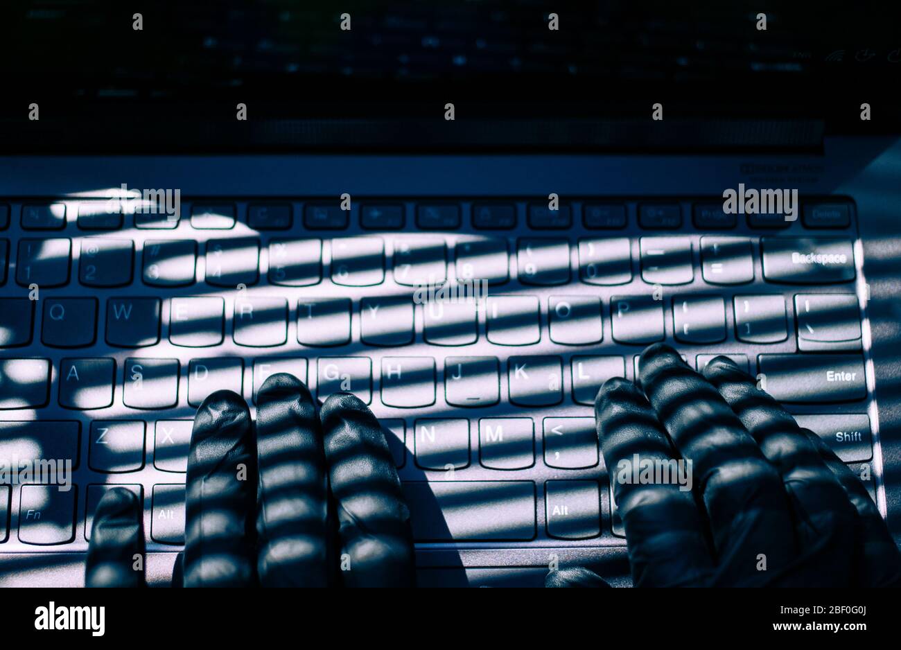 Hand tippen auf der Tastatur mit schwarzen Handschuhen Datenschutz Online-Betrug Hacker Stockfoto