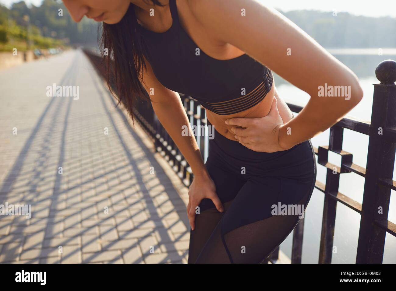 Schmerzen Trauma in der Seite des Magens in einem Mädchen in einem Outdoor-Training. Stockfoto