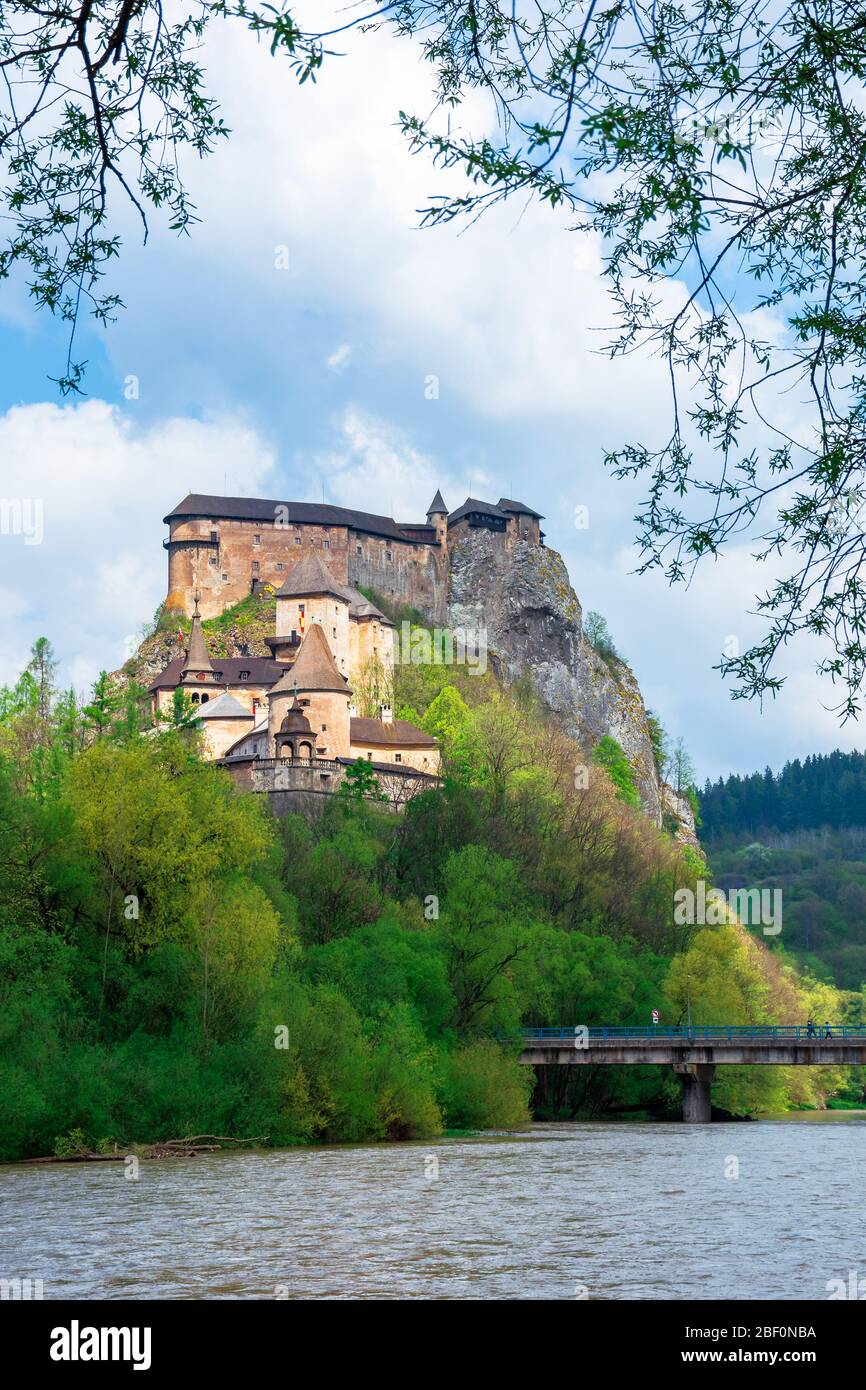 Mittelalterliche orava Burg auf dem Hügel. Schöne Frühlingslandschaft in gesprenkelten Licht über dem Fluss. Beliebtes Reiseziel der slowakei Stockfoto