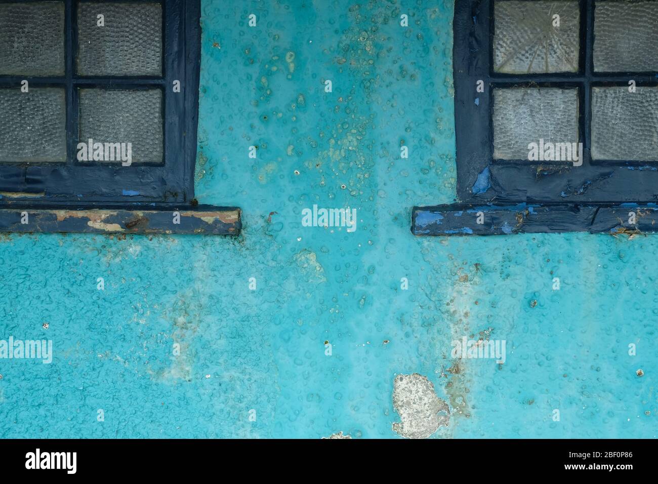 Wand mit dunkelblauen Fensterrahmen Stockfoto