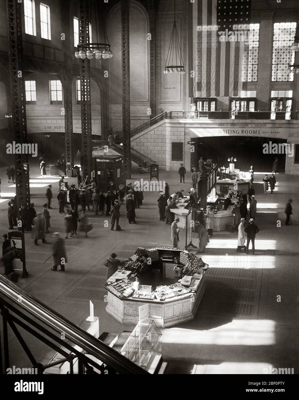 1940ER INNENRAUM UNION STATION PENDLER WARTEN AUF ZÜGE KONZESSION UND INFORMATIONEN KIOSKE AMERIKANISCHE FLAGGE CHICAGO IL USA - Q41774 CPC001 HARS INSPIRATION VEREINIGTE STAATEN VON AMERIKA MÄNNER GEBÄUDE TRANSPORT B & W NORDAMERIKA NORTH AMERICAN RAIL STRUCTURE HIGH ANGLE PENDLER EIGENSCHAFT UNION UND INTERIORS IMMOBILIEN STRUKTUREN STÄDTE INTERIOR DESIGN GEBÄUDE RAILROADS KREATIVITÄT ILLINOIS KIOSKE SCHWARZ UND WEISS IL MIDWEST ALTMODISCH Stockfoto