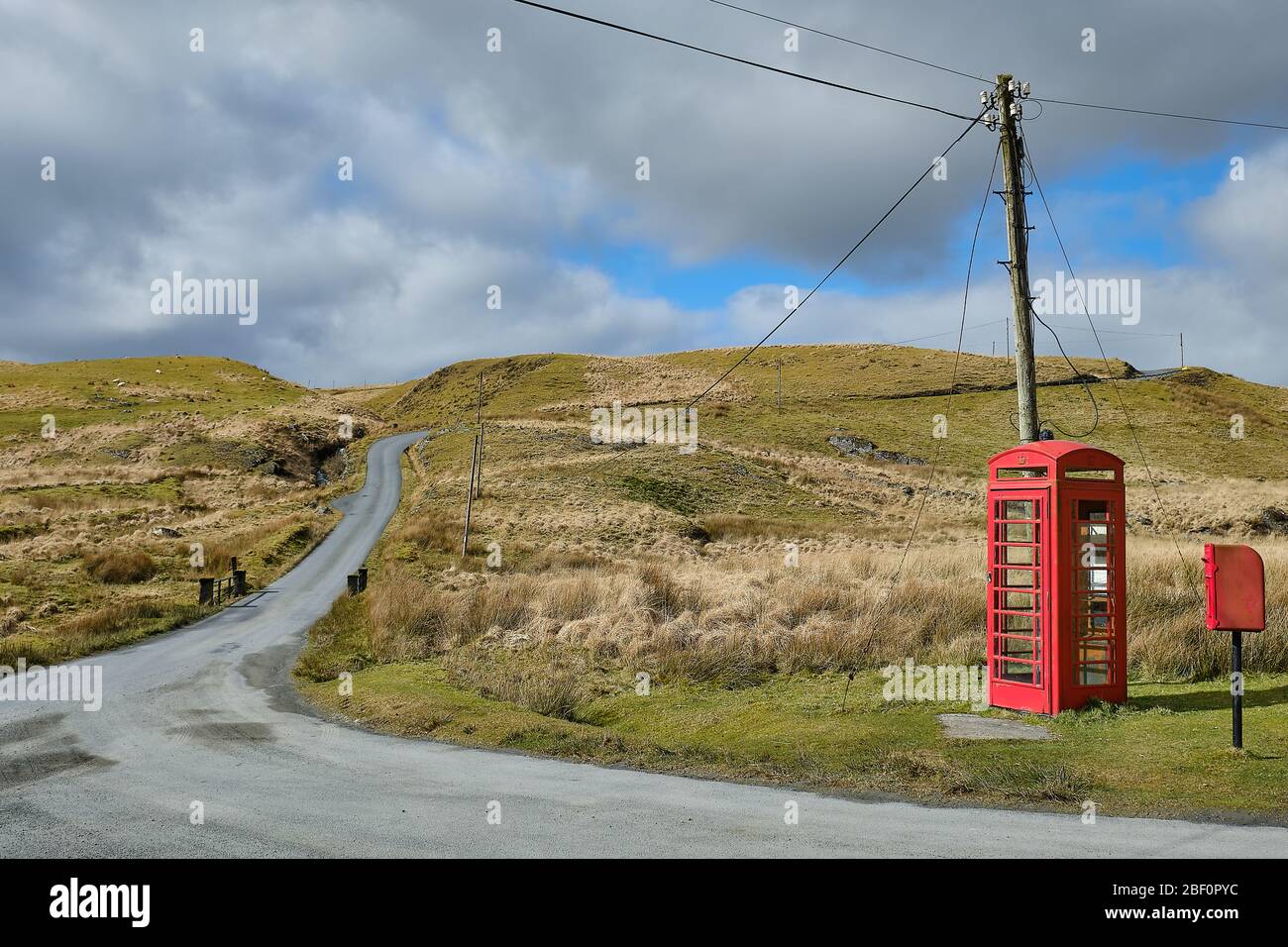 Alte ländliche Telefonzentrale und Briefkasten neben einer einspurigen Straße in den Cambrian Mountains von Mid Wales Stockfoto