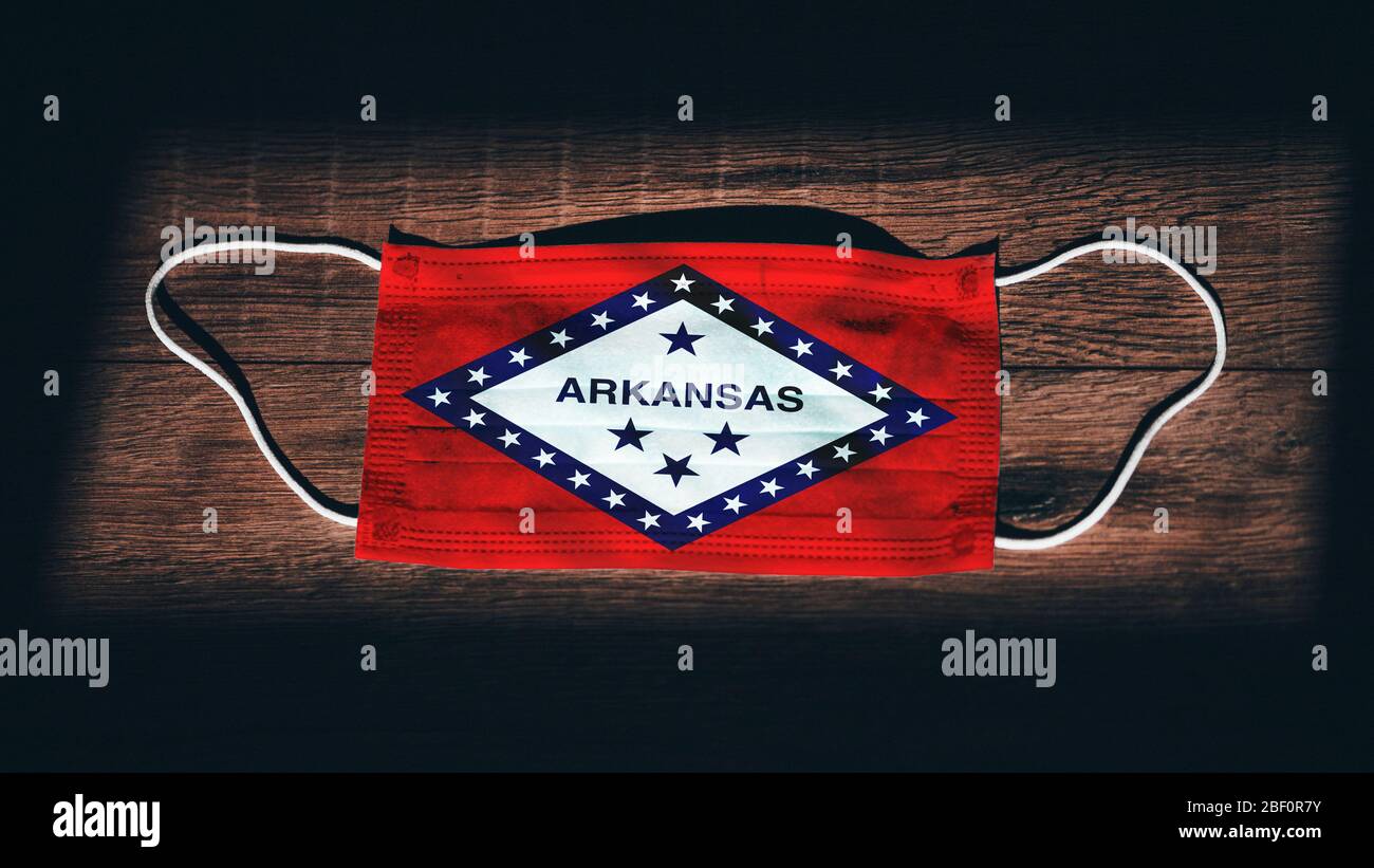 Arkansas-Flagge. Coronavirus Covid 19 im US-Bundesstaat. Medizinische Maske isolieren auf schwarzem Hintergrund. Gesicht und Mund Masken zum Schutz vor Luft in Stockfoto