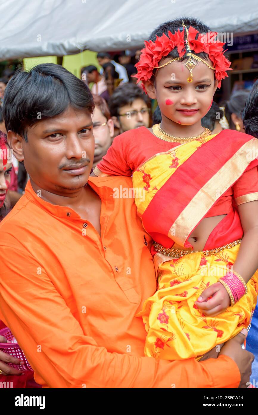 Ein Mädchen mit seinem Vater nimmt am letzten Tag der Durga-Puja-Puja am Baghbazar Sarbojanin in Kolkata am 2019. Oktober an Sindur Khela Teil Stockfoto