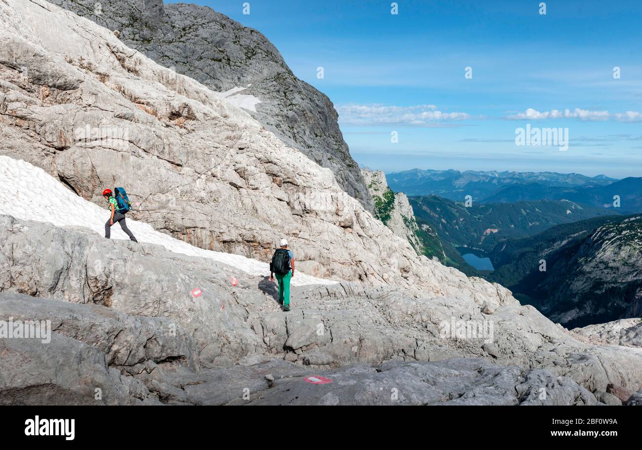 Bergsteigerinnen auf markierter Route durch felsiges alpines Gelände, von Simonyhütte bis Adamekhütte, mit Blick auf Gossausee, Salzkammergut, Obere Stockfoto