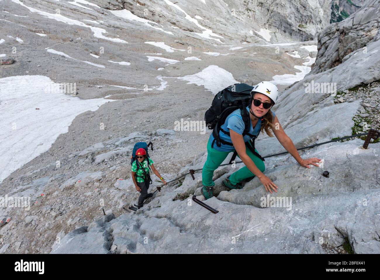 Bergsteigerinnen klettern Felswand, gesicherte Route von Simonyhütte nach Adamekhütte, felsiges alpines Gelände, Salzkammergut, Oberösterreich, Österreich Stockfoto