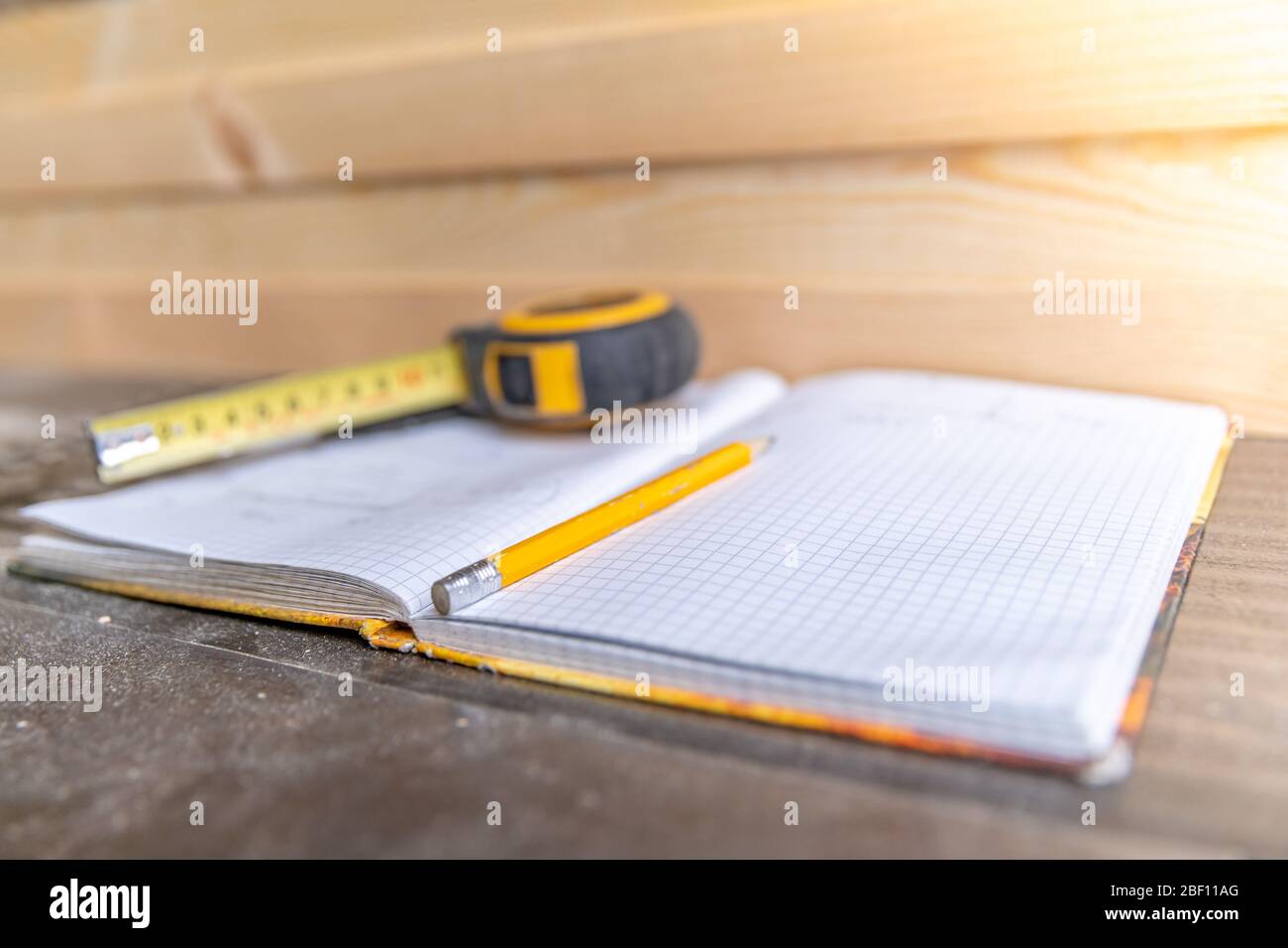 Arbeitsbuch, Bleistift und Meter für die Planung von Holzmöbeln in Tischlerei Stockfoto