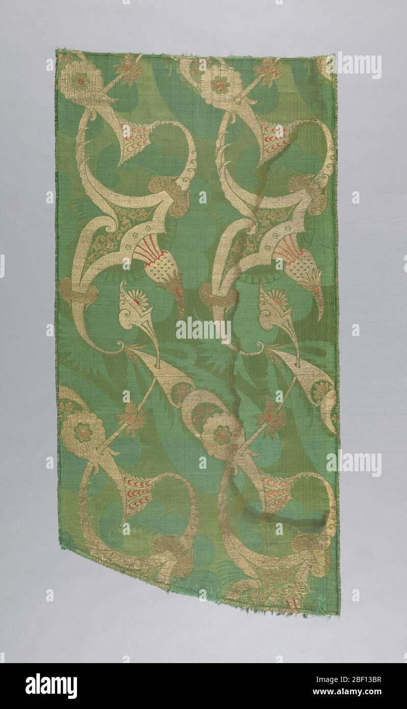 Textil. Stück Brokatseide mit einem "bizarren" Stil Design von übertriebenen krummlinigen Formen piercing und durch foliate Formen durchbohrt. In Gold und Silber Faden mit roten Akzenten auf grünem Grund. Stockfoto