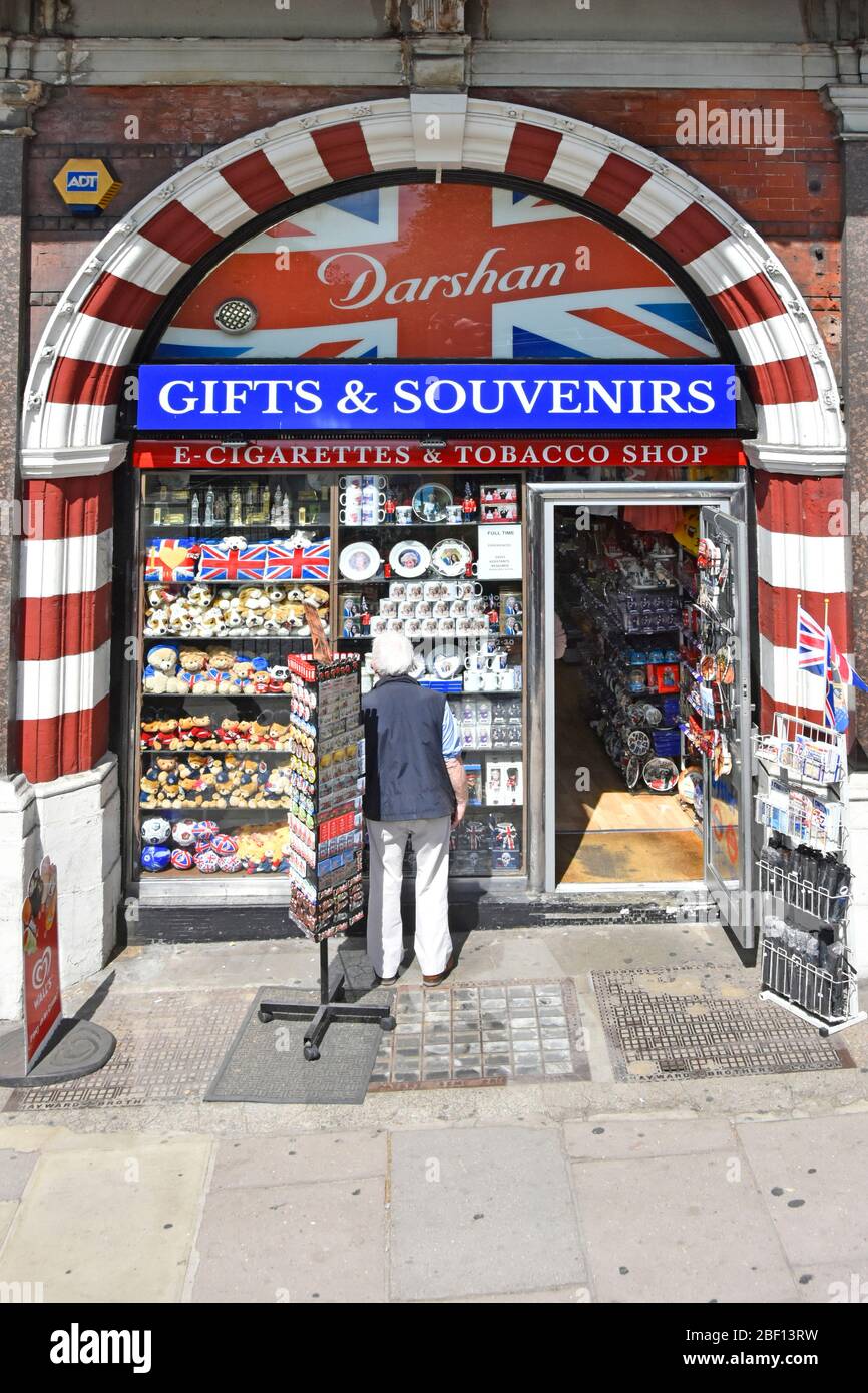 Person Schaufenster Einkaufen außerhalb offen kleine Geschenke & Souvenirs Shop auch Verkauf von Zigaretten & Tabak in der Touristengegend Piccadilly Road London England GB Stockfoto