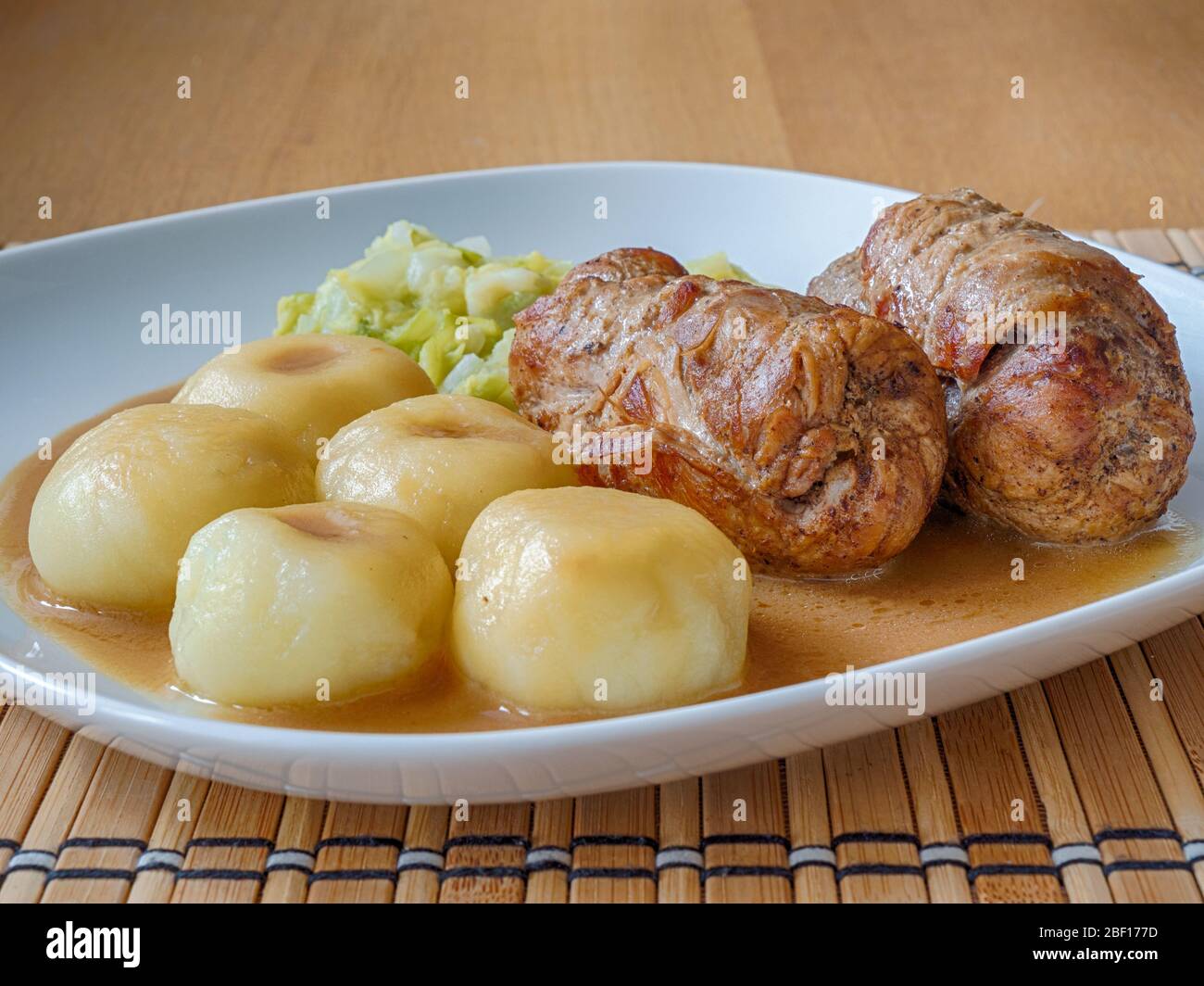 Schlesische Knödel mit Schweinefleisch Roulade und Kohl in Rostsoße Stockfoto