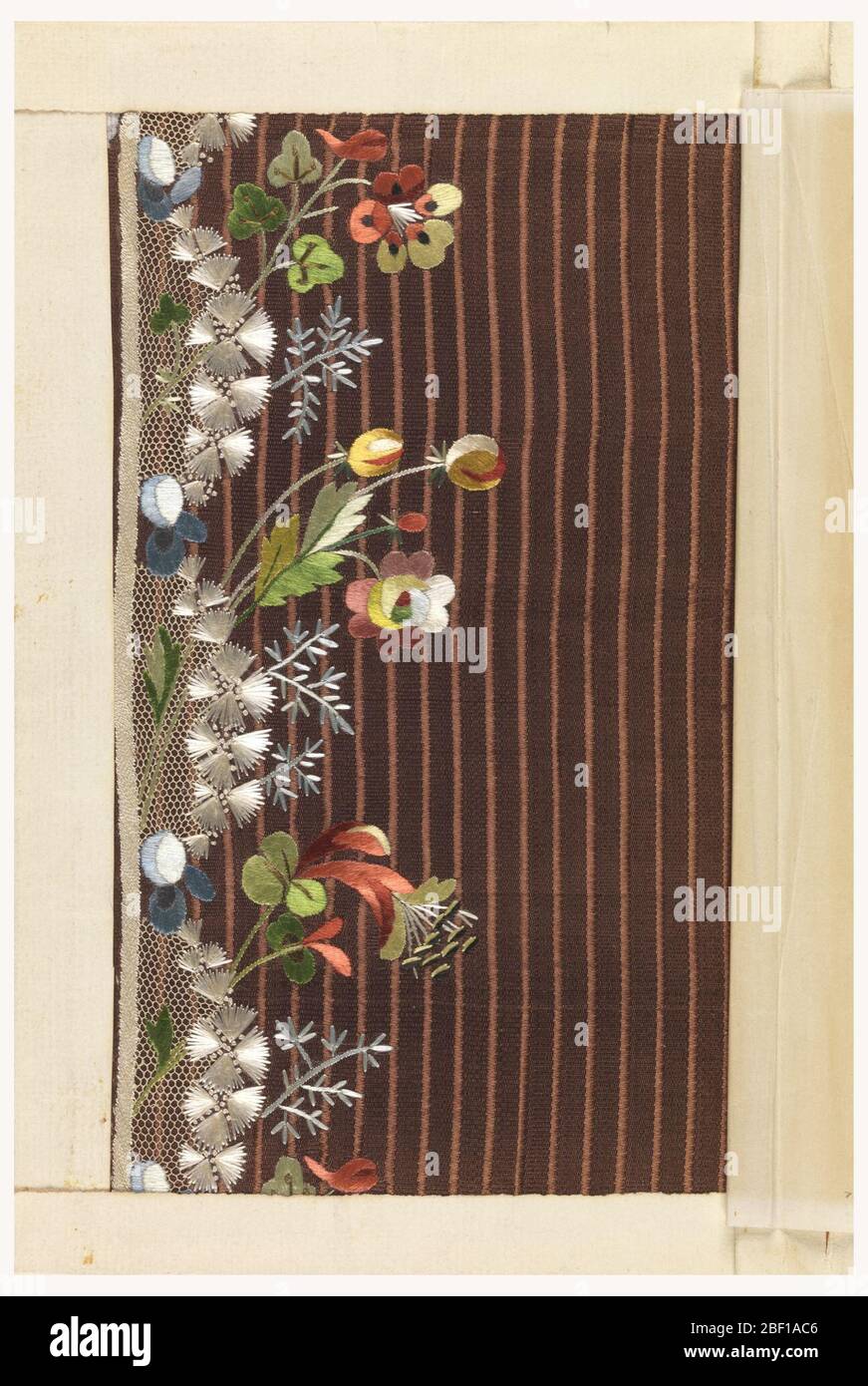 Stickmuster. Mehrfarbige Stickerei im floralen Dessin mit Netzapplikation auf braunem Grundstoff. Stockfoto